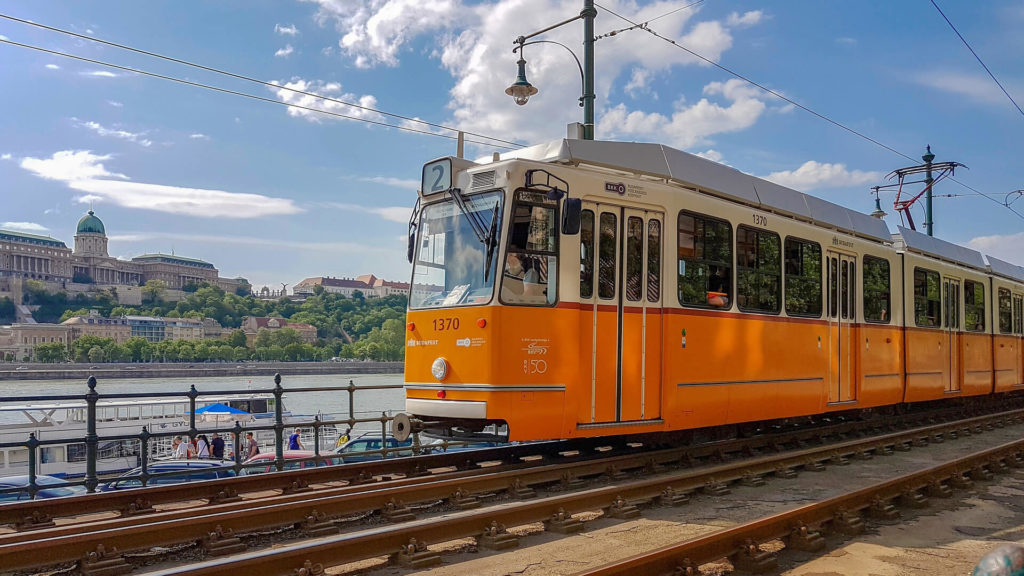 photo of a classic yellow tram traveling on line number 2 in budapest