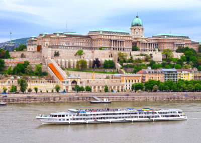 Photo showing the castle district in Budapest, the royal palace and a cruise ship passing by the Danube river